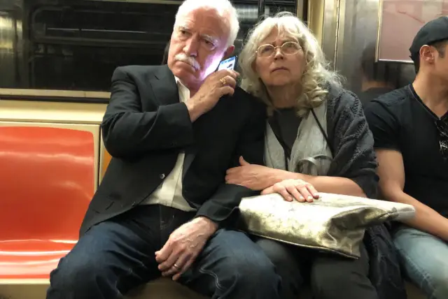 Two people listen to the Kavanaugh hearings on the subway today